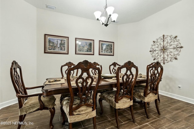 dining area featuring baseboards, a chandelier, and wood finish floors