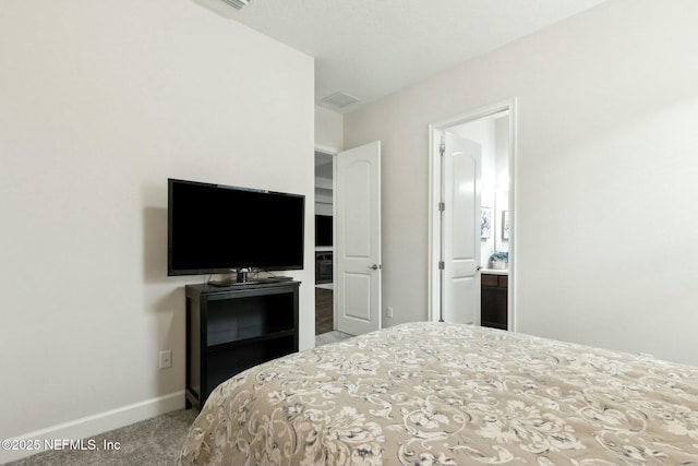 bedroom featuring carpet floors, baseboards, and connected bathroom