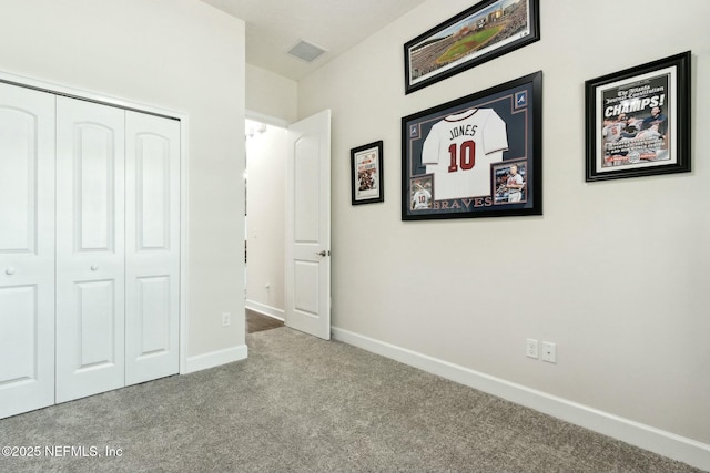 unfurnished bedroom featuring carpet floors, baseboards, visible vents, and a closet