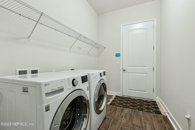 laundry room featuring laundry area, wood tiled floor, baseboards, and independent washer and dryer