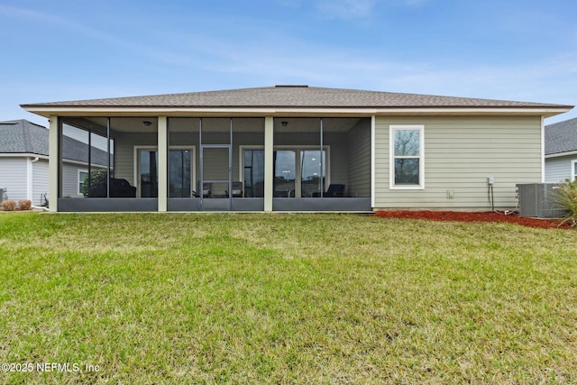 back of property with a lawn, a sunroom, and central air condition unit