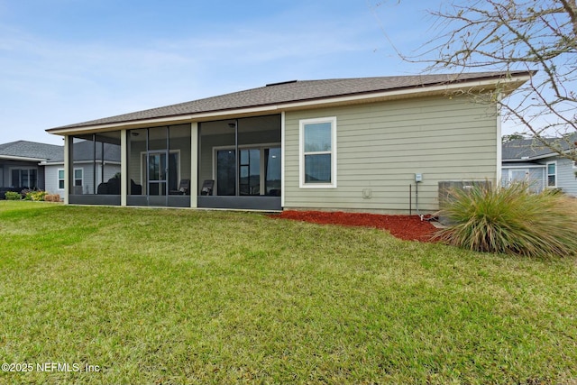 rear view of house with a sunroom and a lawn