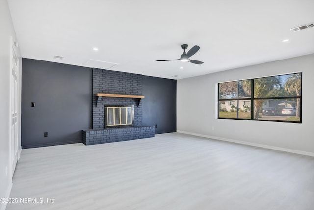 unfurnished living room with light wood-style floors, baseboards, a fireplace, and visible vents