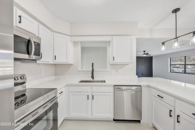 kitchen featuring ceiling fan, appliances with stainless steel finishes, white cabinets, and a sink