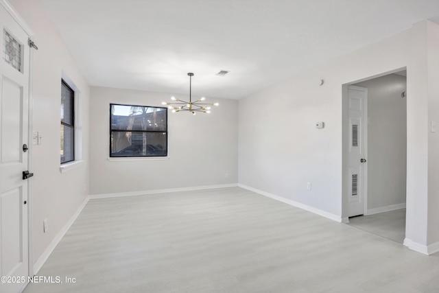 empty room with light wood-style floors, baseboards, visible vents, and a chandelier