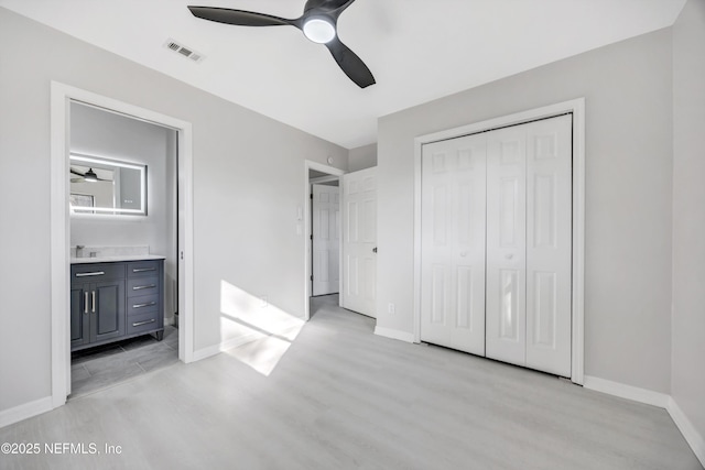 unfurnished bedroom featuring baseboards, a closet, visible vents, and light wood-style floors