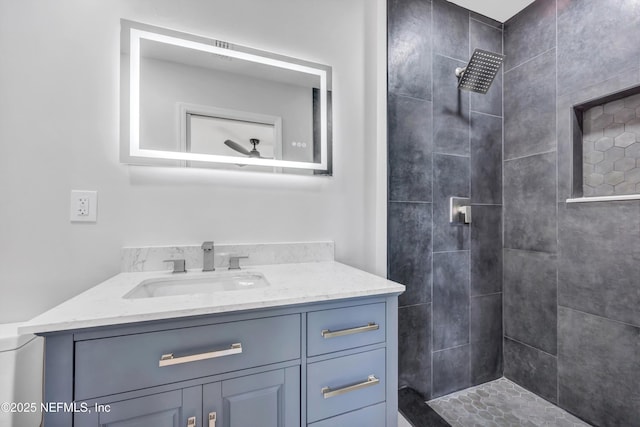 bathroom featuring a tile shower and vanity