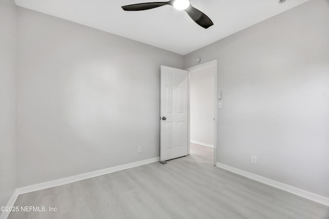 spare room featuring ceiling fan, wood finished floors, and baseboards