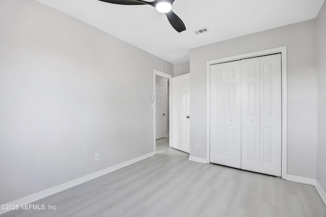 unfurnished bedroom with baseboards, visible vents, a ceiling fan, light wood-style flooring, and a closet