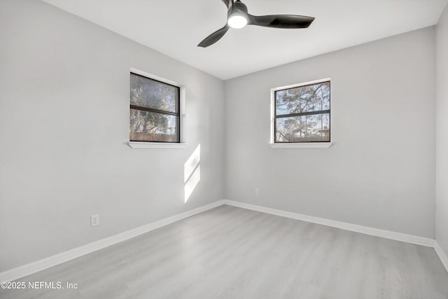 unfurnished room featuring a ceiling fan, baseboards, and wood finished floors