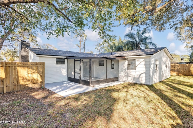 rear view of property with a yard, a patio area, fence, and a sunroom