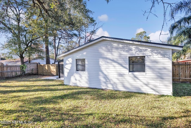 rear view of house featuring a yard and a fenced backyard