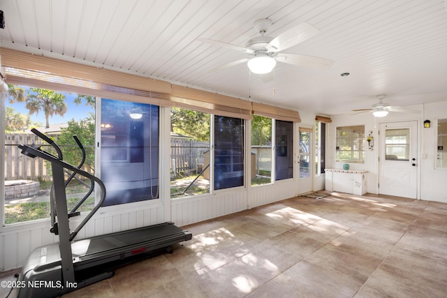 unfurnished sunroom with a ceiling fan and a healthy amount of sunlight