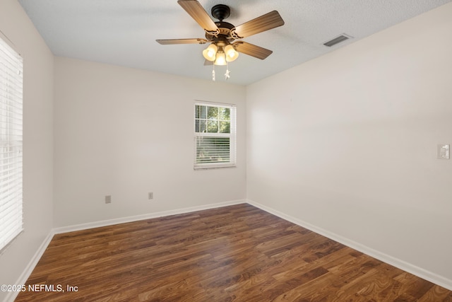 unfurnished room with a ceiling fan, baseboards, visible vents, and wood finished floors