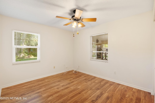 unfurnished room with a healthy amount of sunlight, light wood finished floors, baseboards, and a ceiling fan