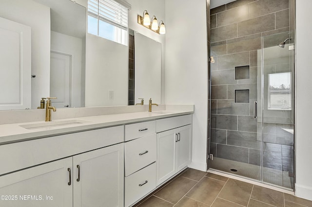 bathroom featuring a stall shower, a sink, and double vanity