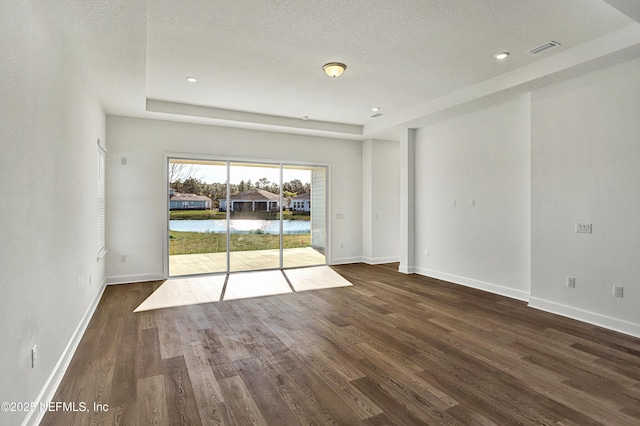 spare room featuring dark wood finished floors, recessed lighting, visible vents, a textured ceiling, and baseboards