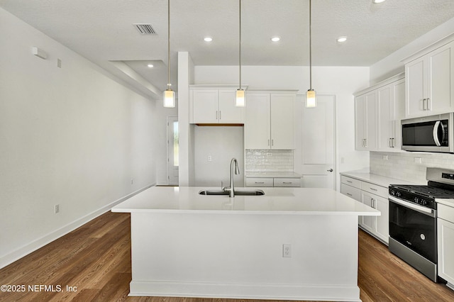 kitchen with dark wood-type flooring, visible vents, stainless steel appliances, and a sink