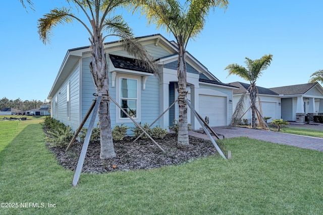 ranch-style house with a garage, a front lawn, and decorative driveway