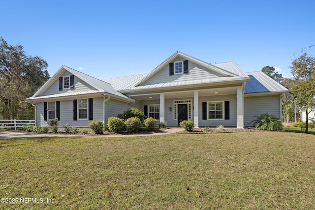 view of front of property featuring metal roof, a front lawn, and fence