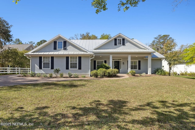 view of front of property with a standing seam roof, fence, metal roof, and a front yard