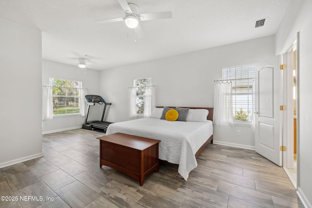 bedroom with multiple windows, visible vents, and baseboards