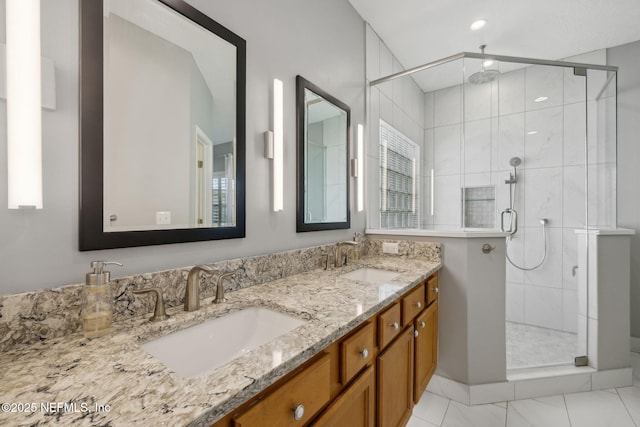 full bath with double vanity, a stall shower, and a sink