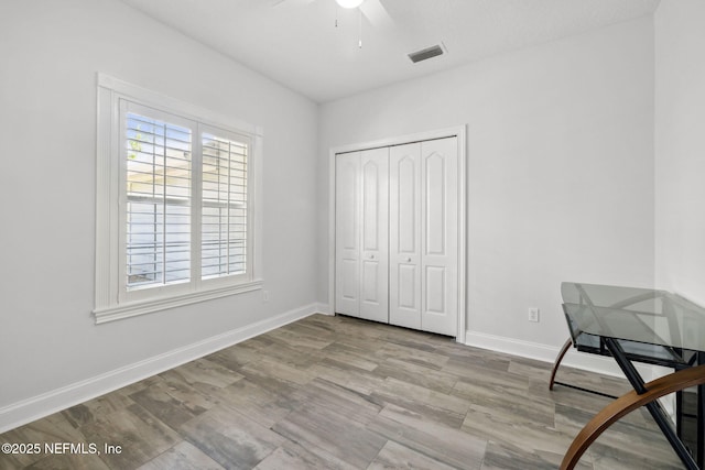 unfurnished room featuring visible vents, baseboards, a ceiling fan, and wood finished floors