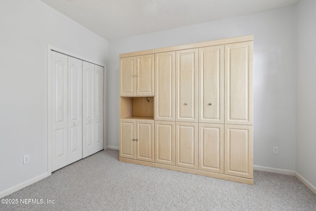 unfurnished bedroom with light colored carpet and baseboards