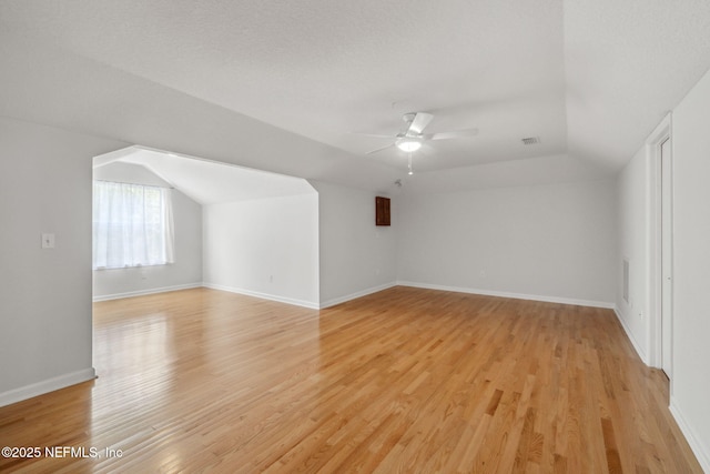 additional living space featuring light wood-type flooring, visible vents, a ceiling fan, and lofted ceiling