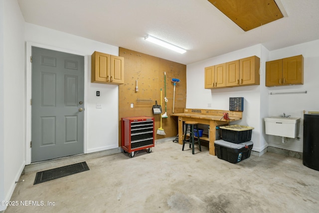 garage with a sink, visible vents, and a workshop area