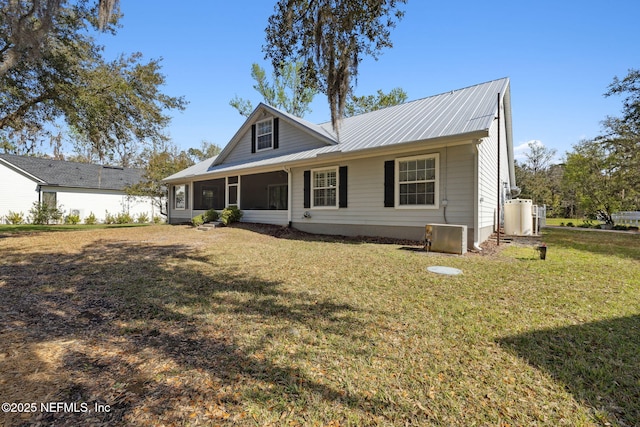 view of front of house with a front yard, a sunroom, and metal roof