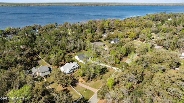 drone / aerial view featuring a water view and a forest view