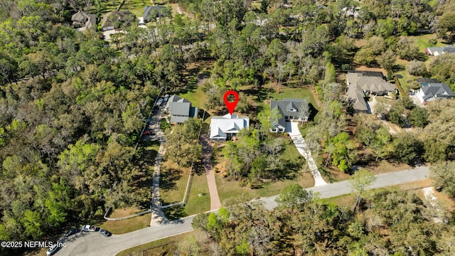 birds eye view of property featuring a wooded view