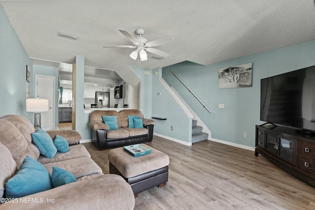 2211 1st St S, Jacksonville Beach, FL 32250 - living room with light wood finished floors, a ceiling fan, visible vents, and stairs