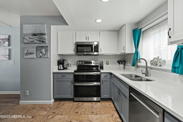 2211 1st St S, Jacksonville Beach, FL 32250 - kitchen with white cabinetry, light countertops, a sink, stainless steel appliances, and gray cabinetry