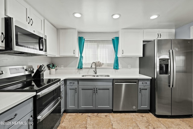 2211 1st St S, Jacksonville Beach, FL 32250 - kitchen with light countertops, white cabinetry, gray cabinetry, appliances with stainless steel finishes, and a sink
