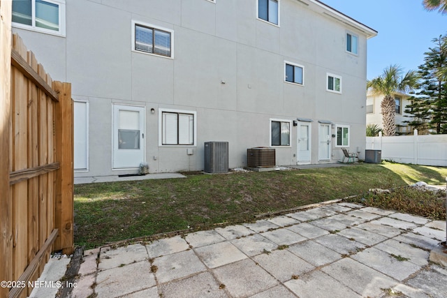 2211 1st St S, Jacksonville Beach, FL 32250 - back of property with a yard, a patio, stucco siding, and central air condition unit