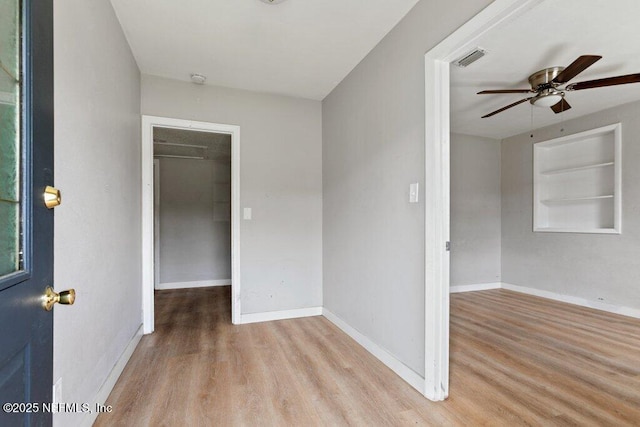 empty room with ceiling fan, baseboards, and wood finished floors