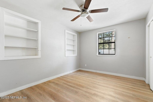 3135 Soutel Dr, Jacksonville, FL 32208 - spare room featuring ceiling fan, built in shelves, wood finished floors, and baseboards