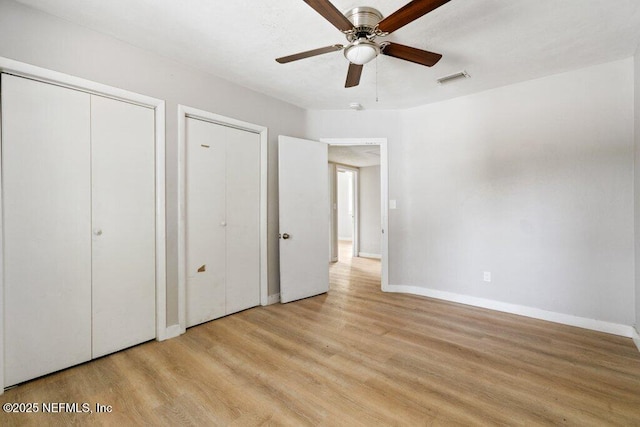 3135 Soutel Dr, Jacksonville, FL 32208 - unfurnished bedroom featuring a ceiling fan, baseboards, visible vents, multiple closets, and light wood-type flooring