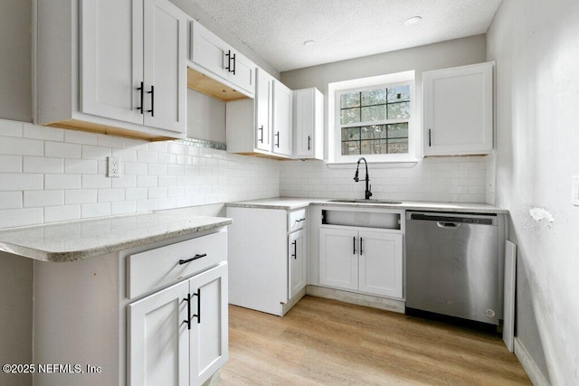 3135 Soutel Dr, Jacksonville, FL 32208 - kitchen with light wood finished floors, backsplash, a sink, a textured ceiling, and dishwasher