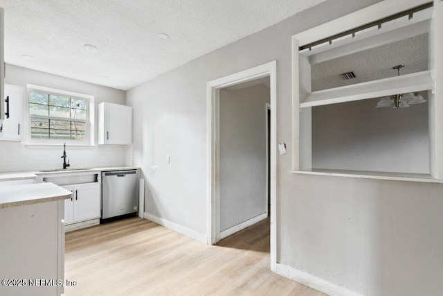 3135 Soutel Dr, Jacksonville, FL 32208 - kitchen with a sink, white cabinets, dishwasher, and light countertops