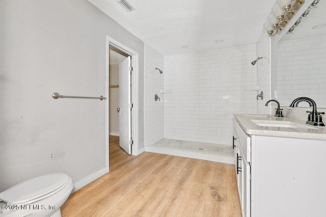 3135 Soutel Dr, Jacksonville, FL 32208 - full bathroom featuring wood finished floors, visible vents, a textured ceiling, and tiled shower