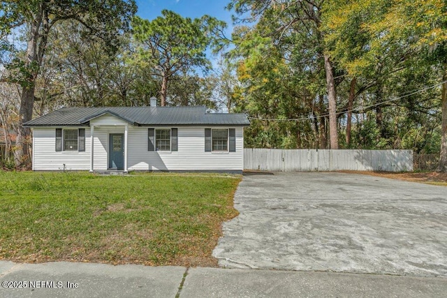 3135 Soutel Dr, Jacksonville, FL 32208 - view of front facade with driveway, fence, metal roof, and a front yard