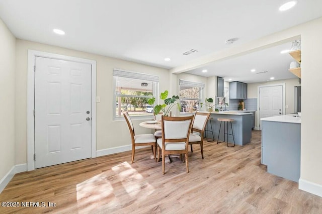 dining area with light wood-style floors, baseboards, visible vents, and recessed lighting