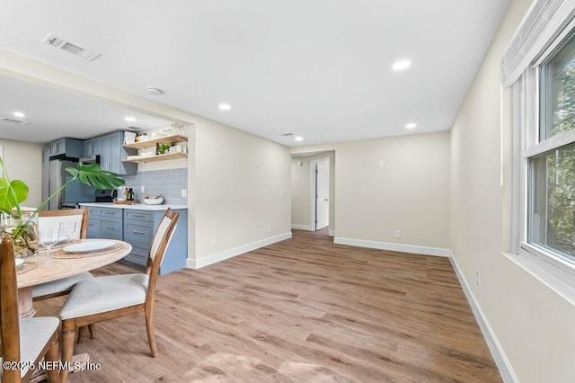 dining space featuring baseboards, plenty of natural light, visible vents, and light wood-style floors