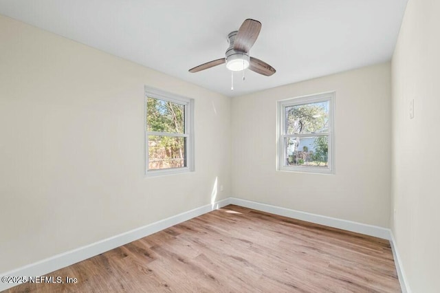 empty room with light wood-type flooring, plenty of natural light, and baseboards