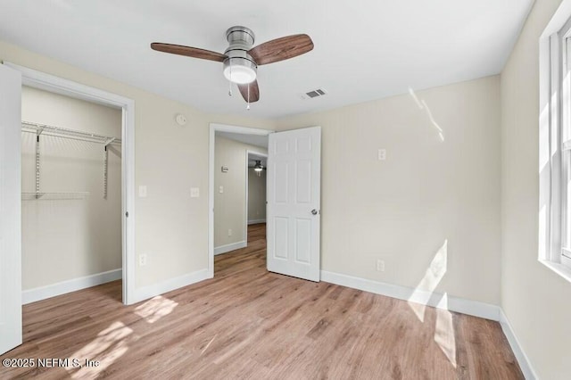 unfurnished bedroom featuring baseboards, visible vents, and wood finished floors