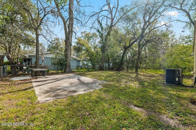 view of yard with fence, cooling unit, and a patio